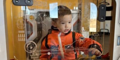 Boy plays in a spaceship arcade type game at Observer Ranch in Penrose, Colorado