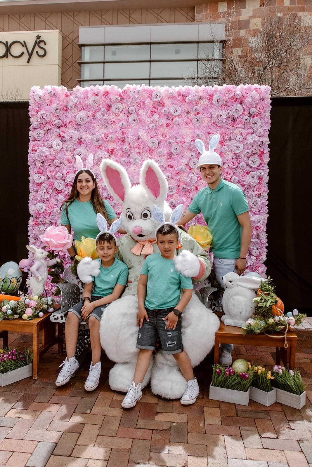 Family poses for photo wearing rabbit ear headbands at the Orchard Town Hall Center